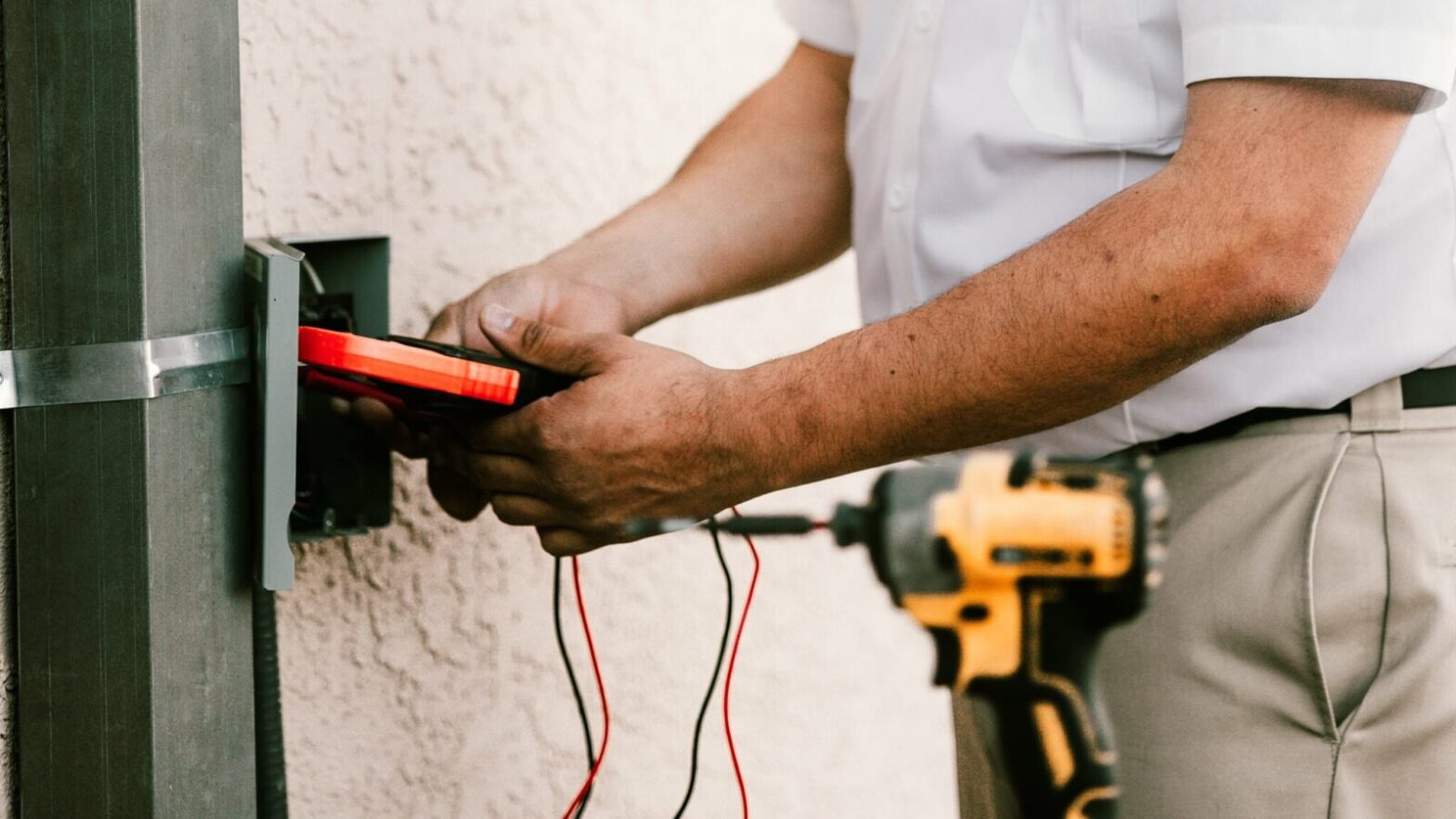 Licensed Livermore electrician testing a circuit with a multimeter to diagnose a breaker that keeps tripping